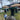 Dog wearing a blue pouty paws cooling bandana in front of a Mexican food stand with thatched roof