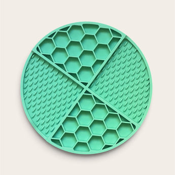 Round mint green Pouty Paws dog lick mat with divided honeycomb and raised-texture sections