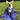 Corgi sitting on grass wrapped in a blue Pouty Paws dog towel with red and white print
