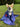 Corgi sitting on grass wrapped in a blue Pouty Paws dog towel with red and white print